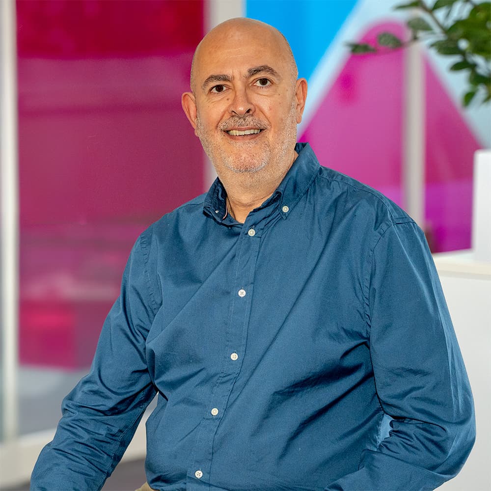 Photo of Steven Underwood, Commercial Sales Team Leader at Utilita Business, sat in front of colourful glass panels.