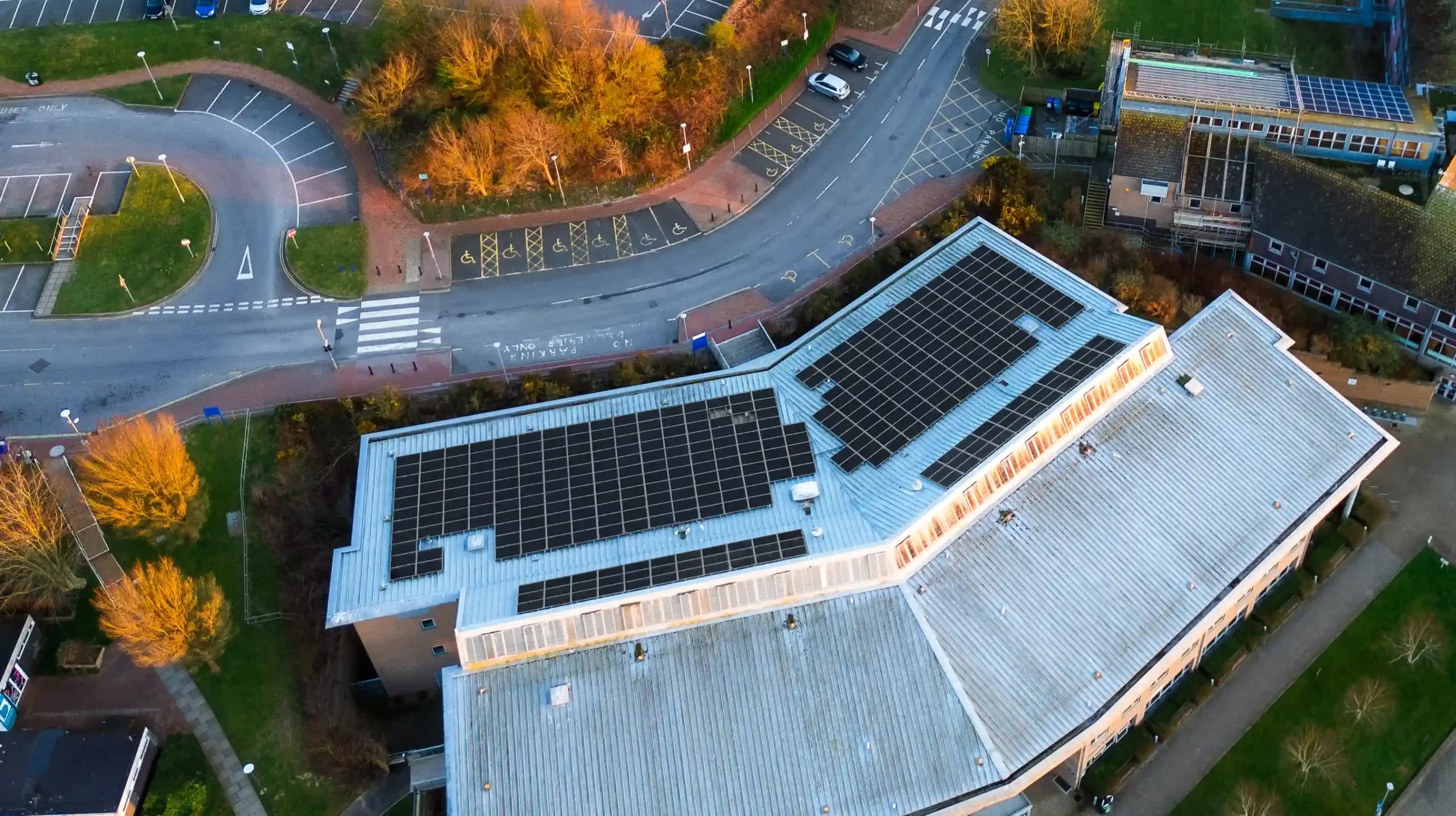 Aerial view of a public sector building with commercial solar panels installed on the roof from Utilita Business.