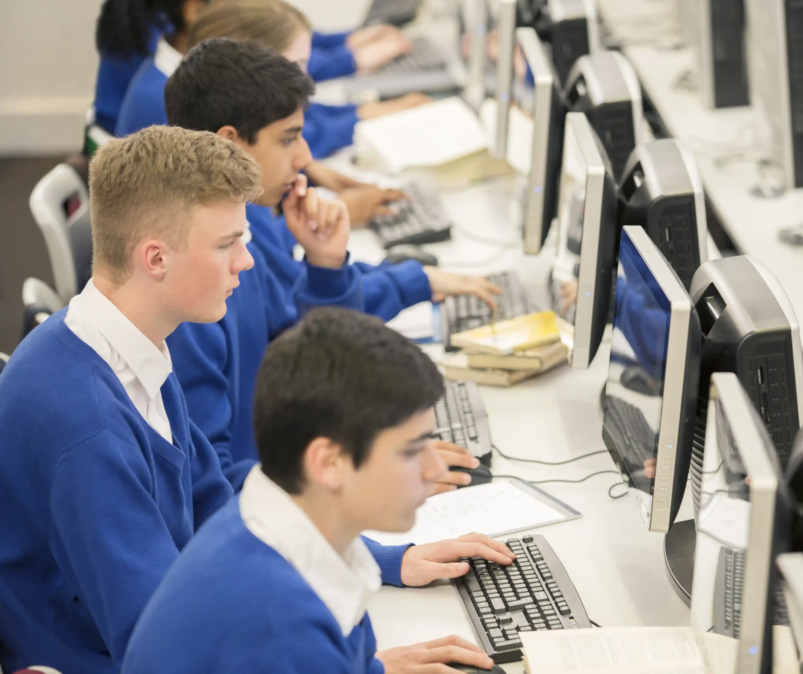 Class of school children working on desktop computers powered by renewable energy generated by solar for the public sector.