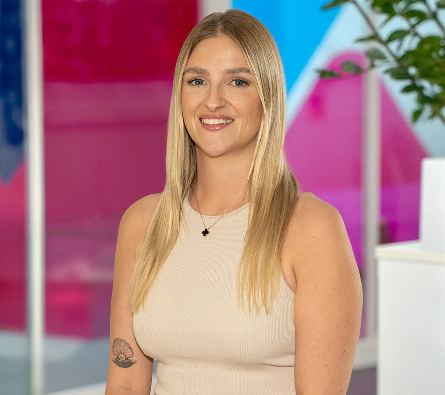 Photo of Josie Gratton, Commercial Sales Manager at Utilita Business, sat in front of colourful glass panels.