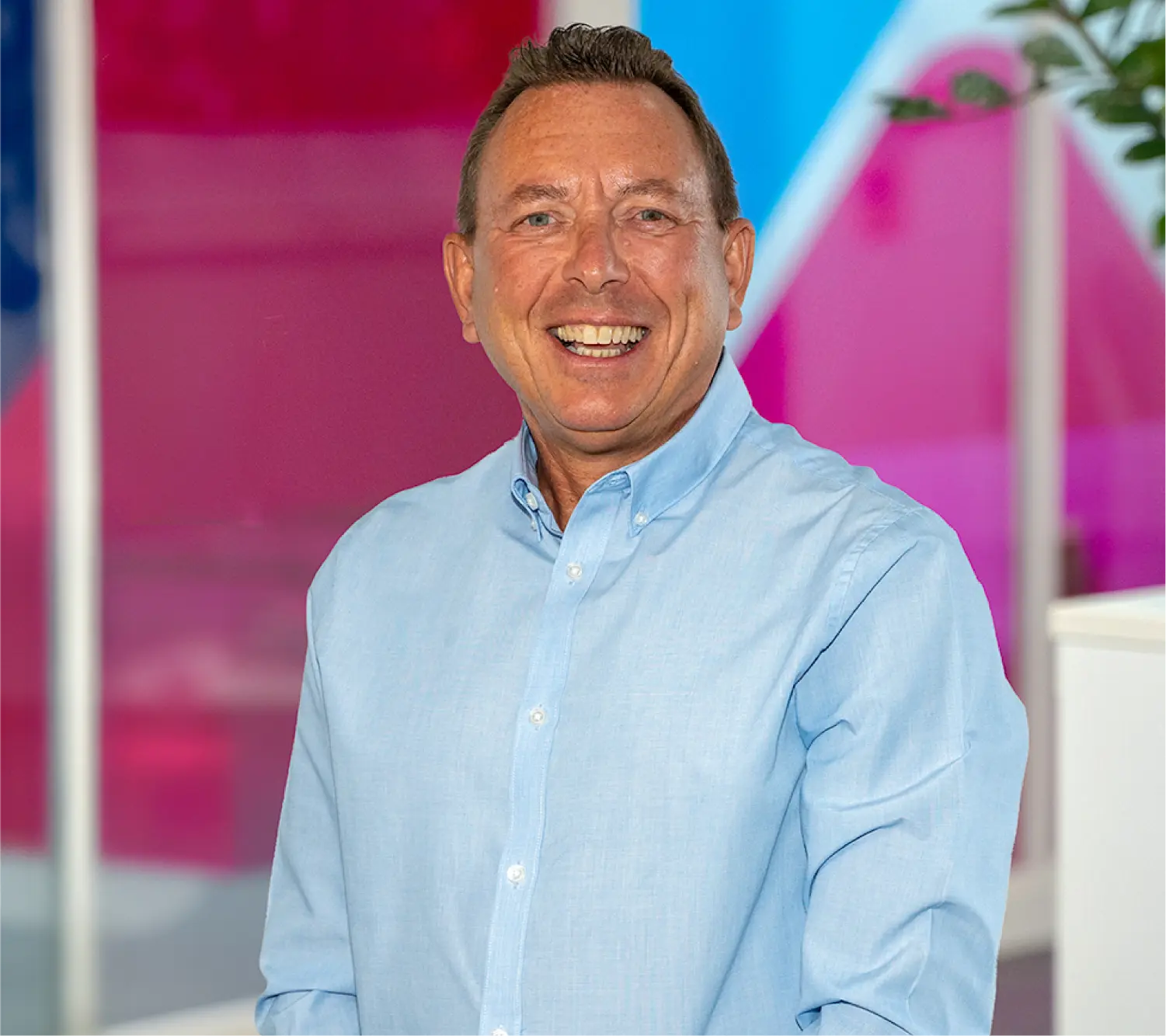 Photo of Julian Finegold, Business Development Manager at Utilita Business, sat in front of colourful glass panels.