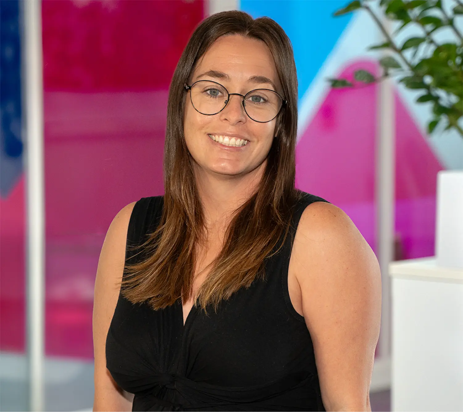 Photo of Tina Littleton, Commercial Sales Operations Manager at Utilita Business, sat in front of colourful glass panels.